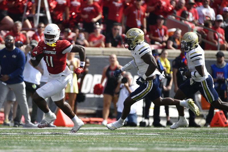 Louisville tight end Jamari Johnson (11) runs from the defense of Georgia Tech linebacker Trenilyas Tatum (0), center, and defensive back Taye Seymore (7) during the first half of an NCAA college football game in Louisville, Ky., Saturday, Sept. 21, 2024. (AP Photo/Timothy D. Easley)