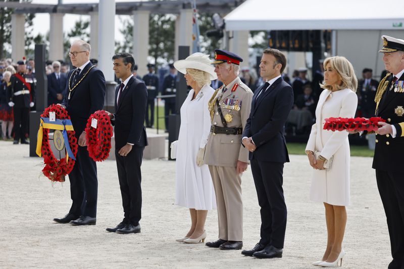 Prime Minister of the United Kingdom, Rishi Sunak, second right, Britain's King Charles III and Britain's Queen Camilla with French President Emmanuel Macron, third right, his wife Brigitte Macron, second right, attend a commemorative ceremony marking the 80th anniversary of the World War II D-Day" Allied landings in Normandy, at the World War II British Normandy Memorial of Ver-sur-Mer, Thursday, June 6, 2024. Normandy is hosting various events to officially commemorate the 80th anniversary of the D-Day landings that took place on June 6, 1944. (Ludovic Marin/Pool via AP)