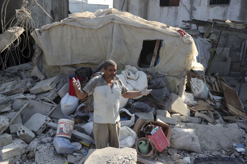 A man reacts as he stands on the rubble of a building hit in an Israeli airstrike in the southern village of Akbieh, Lebanon, Tuesday, Sept. 24, 2024. (AP Photo/Mohammed Zaatari)