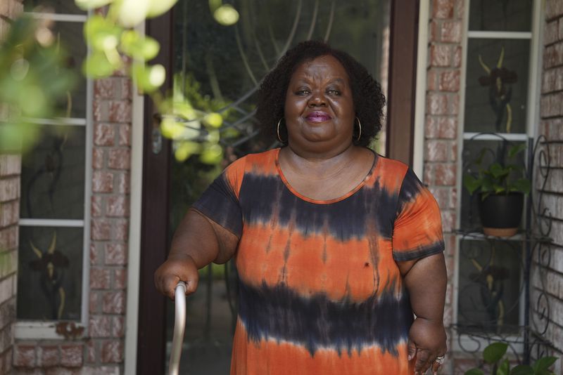 Corrina Jackson, who heads up a local version of the federal Healthy Start program, stands for a portrait outside her home in Tulsa, Okla., on Monday, July 15, 2024. (AP Photo/Mary Conlon)