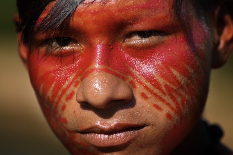 Indigenous youth Yawari Asheninka poses for a picture next to the Amonia River during the annual celebration recognizing the Ashaninka territory in the Apiwtxa village, Acre state, Brazil, Monday, June 24, 2024. (AP Photo/Jorge Saenz)