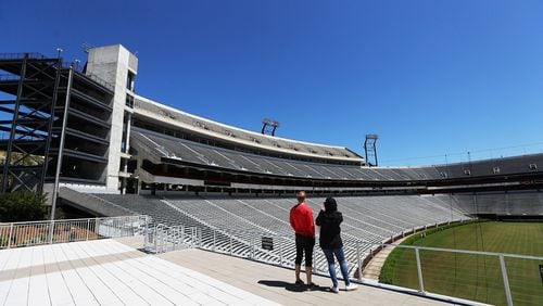 April 2, 2020 Athens: Local residents Dan Haybery and Alexis Biaggi pause to take in an empty Sanford Stadium during a walk across the University of Georgia campus from their home in downtown Athens on Thursday, April 2, 2020. A mandatory shelter in place has been in effect in Athens-Clarke County long before many metro Atlanta towns took similar steps.  Curtis Compton ccompton@ajc.com