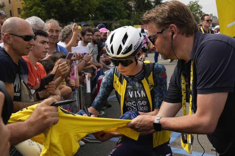 Denmark's Jonas Vingegaard autographs a overall leader's yellow jersey prior to the start of the third stage of the Tour de France cycling race over 230.8 kilometers (143.4 miles) with start in Piacenza and finish in Turin, Italy, Monday, July 1, 2024. (AP Photo/Jerome Delay)