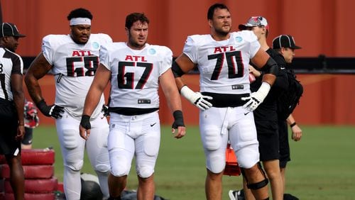 Atlanta Falcons offensive lineman from left to right; Elijah Wilkinson (68), Drew Dalman (67), and Jake Matthews (70) take a breather during training camp at the Falcons Practice Facility, Tuesday, Aug. 2, 2022, in Flowery Branch, Ga. (Jason Getz / Jason.Getz@ajc.com)