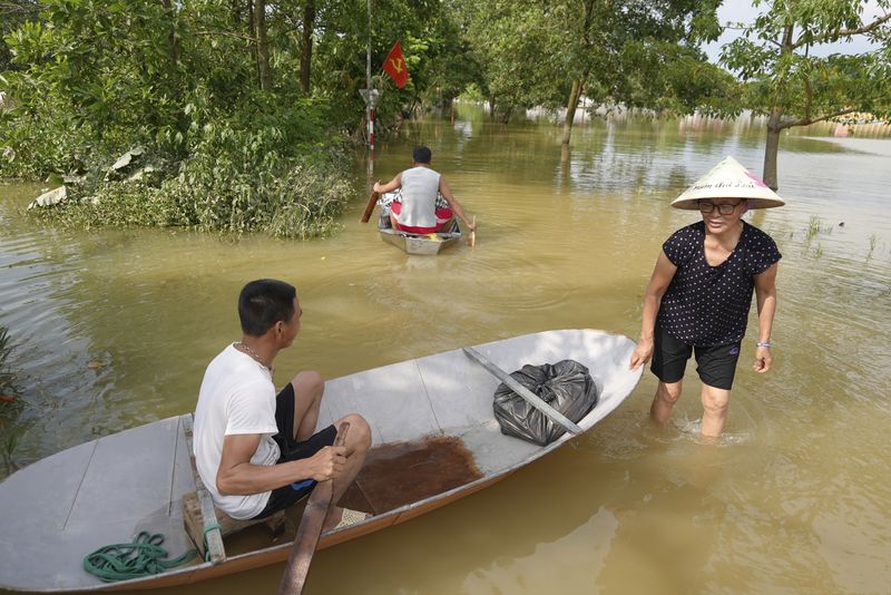 People use boats to get to their flooded homes in the aftermath of Typhoon Yagi in An Lac village, Hanoi, Vietnam Friday, Sept. 13, 2024. (AP Photo/Hau Dinh)