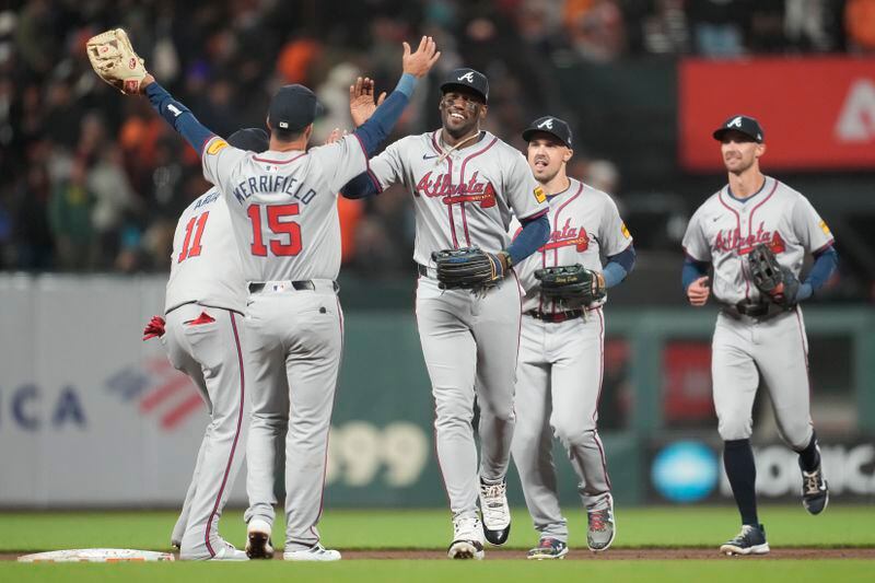 Atlanta Braves second baseman Whit Merrifield (15) celebrates with left fielder Jorge Soler, middle, and teammates after the Braves defeated the San Francisco Giants in 10 innings of a baseball game in San Francisco, Monday, Aug. 12, 2024. (AP Photo/Jeff Chiu)