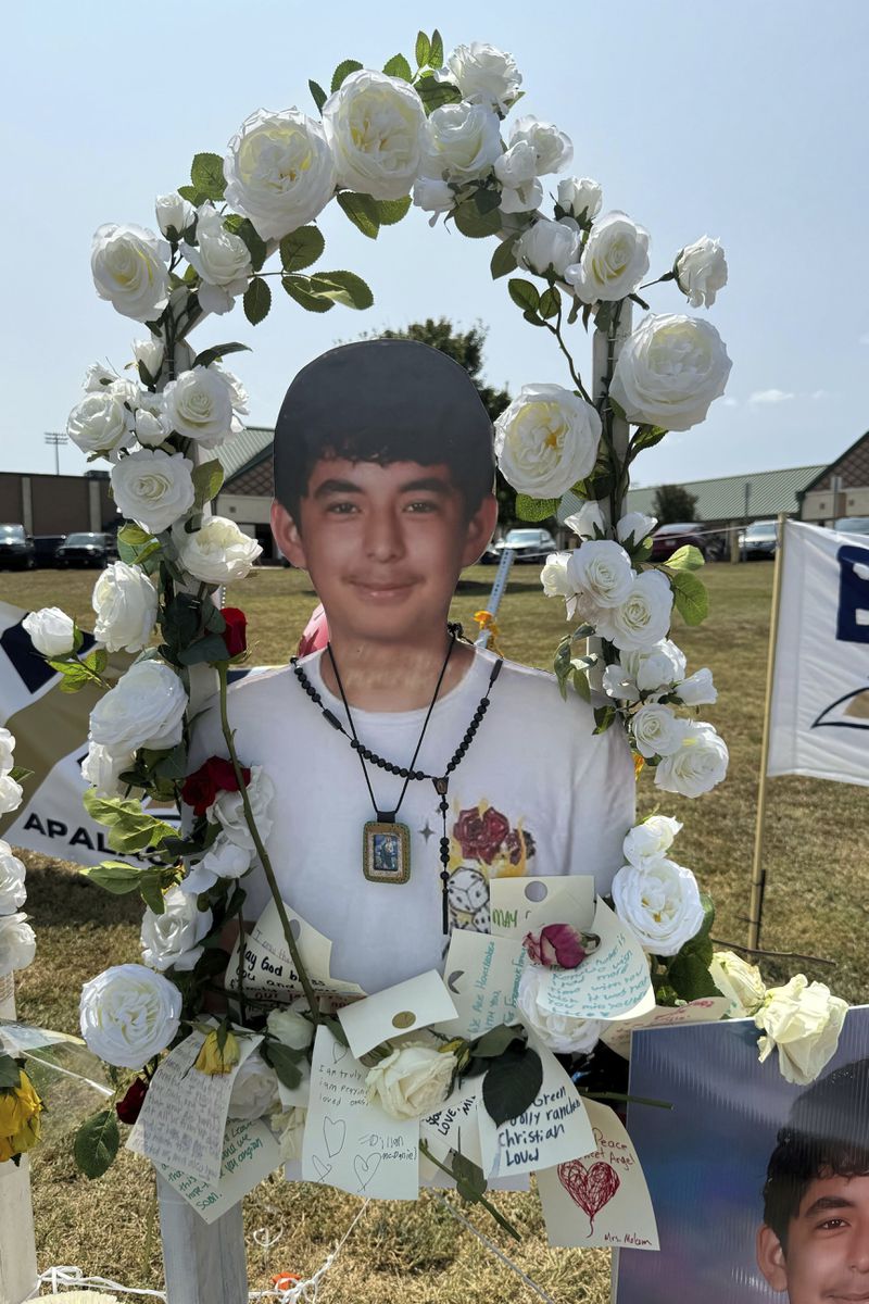 A poster with an image of shooting victim Christian Angulo is displayed at a memorial outside Apalachee High School, Tuesday, Sept. 10, 2024, in Winder, Ga. (AP Photo/Charlotte Kramon)