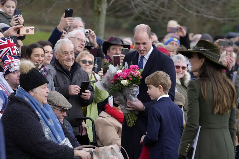 FILE - Prince William, Prince George and Kate, Princess of Wales speak to members of the public after attending the Christmas day service at St Mary Magdalene Church in Sandringham in Norfolk, England, on Dec. 25, 2022. Shortly after U.K. Prime Minister Rishi Sunak called early parliamentary elections for July 4, Buckingham Palace said that all members of the royal family were cancelling most public engagements until after the vote to avoid doing anything that might divert attention from the campaign. (AP Photo/Kirsty Wigglesworth, File)