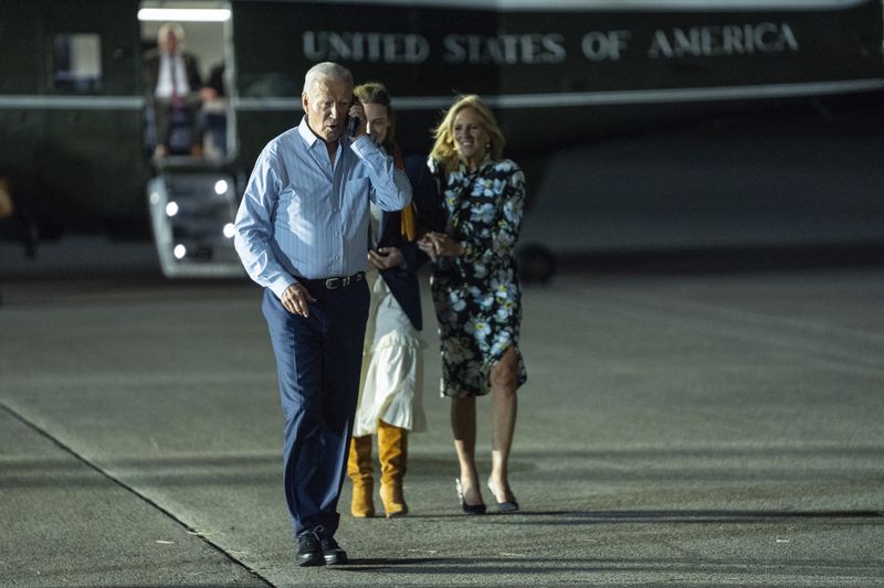 President Joe Biden, left, talks on the phone as he walks to board Air Force One at McGuire Air Force Base, Saturday, June 29, 2024, in Burlington County, N.J. (AP Photo/Evan Vucci)