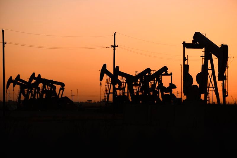 FILE - An array of pumpjacks operate near the site of a new oil and gas well being drilled April 8, 2022 in Midland, Texas. (Eli Hartman/Odessa American via AP, File)