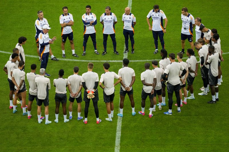 Real Madrid's head coach Carlo Ancelotti, left, talks to players during a training session ahead of the UEFA Super Cup Final soccer match between Real Madrid and Atalanta at the Narodowy stadium in Warsaw, Poland, Tuesday, Aug. 13, 2024. (AP Photo/Darko Vojinovic)