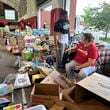 N.C. State defensive end Davin Vann and his mother, Joy Hall, work among the donations collected to help Hurricane Helene victims in western North Carolina, Wednesday, Oct. 2, 2024 in Raleigh, N.C. (AP Photo/Aaron Beard)