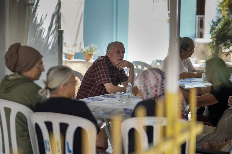 Mehmet, the father of Aysenur Ezgi Eygi, the 26 year-old Turkish-American activist killed by the Israeli military, center, sits with others outside the family house in City of Didim, Turkey, Thursday, Sept. 12, 2024. (AP Photo/Khalil Hamra)