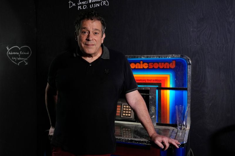 Robert Kesten, executive director of the Stonewall Museum, stands next to a juke box at the museum, Wednesday, June 26, 2024, in Fort Lauderdale, Fla. The Stonewall Museum hosts a comprehensive archive on LGBTQ+ history and the largest library collection in the world. The museum is one of hundreds of art and culture groups in the state that are left scrambling to plug a large budget gap after Gov. Ron De Santis vetoed $32 million in arts funding. (AP Photo/Marta Lavandier)