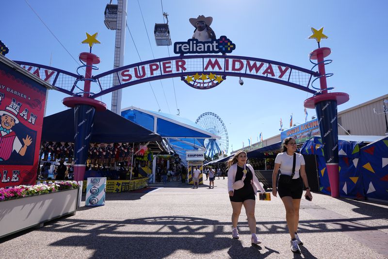 Guests make their way through the Super Midway at the State Fair of Texas in Dallas on Friday, Sept. 27, 2024. (AP Photo/Tony Gutierrez)