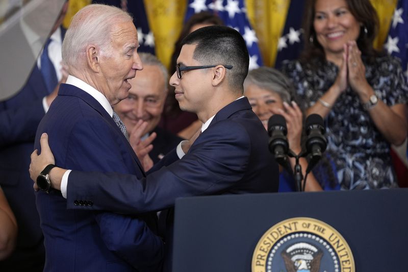 Javier Quiroz Castro gives a hug to President Joe Biden at an event marking the 12th anniversary of the Deferred Action of Childhood Arrivals program, in the East Room of the White House, Tuesday, June 18, 2024, in Washington. (AP Photo/Evan Vucci)
