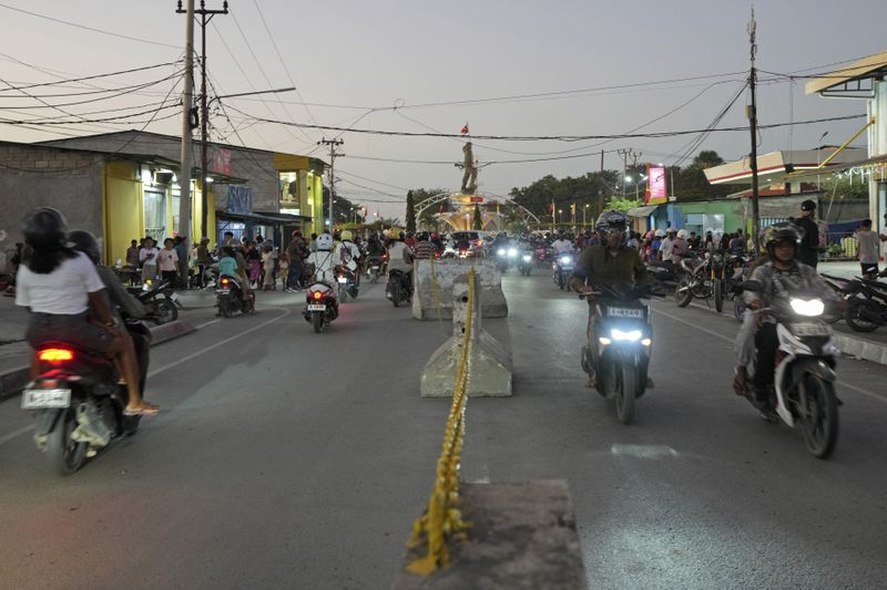 Motorcyclists move along a street where vendors have been removed in preparation of the visit of Pope Francis in Dili, East Timor on Sunday, Sept. 8, 2024. (AP Photo/Firdia Lisnawati)