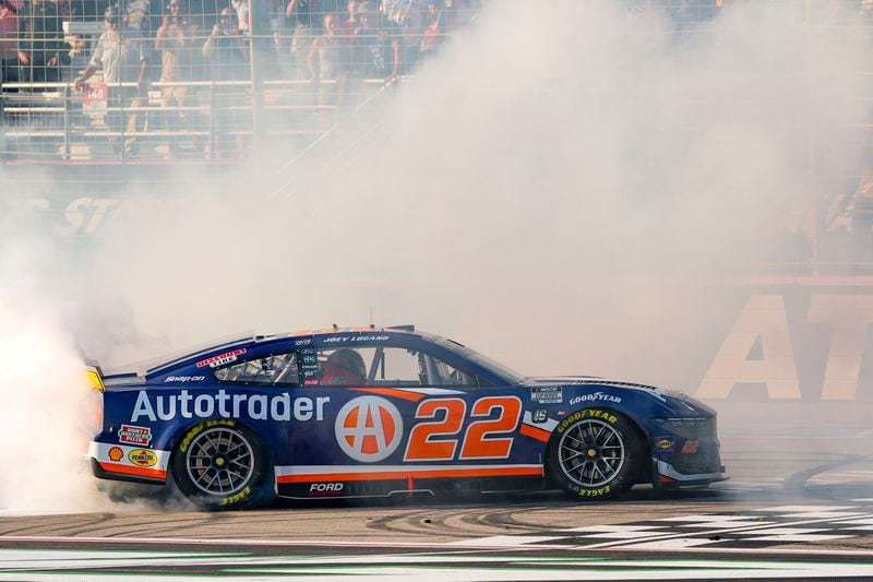 Joey Logano (22) does a burnout near the finish line after winning a NASCAR Cup Series auto race Sunday, Sept. 8, 2024, in Hampton, Ga. (AP Photo/Jason Allen)