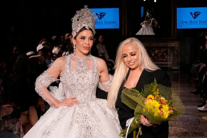 Wearing an April Black Diamond creation, Emma Coronel, wife of Joaquin "El Chapo" Guzman, poses for a photo with the designer during a Spring Summer 2025 collection presentation, in Milan, Italy, Sunday, Sept. 22, 2024. (AP Photo/Antonio Calanni)