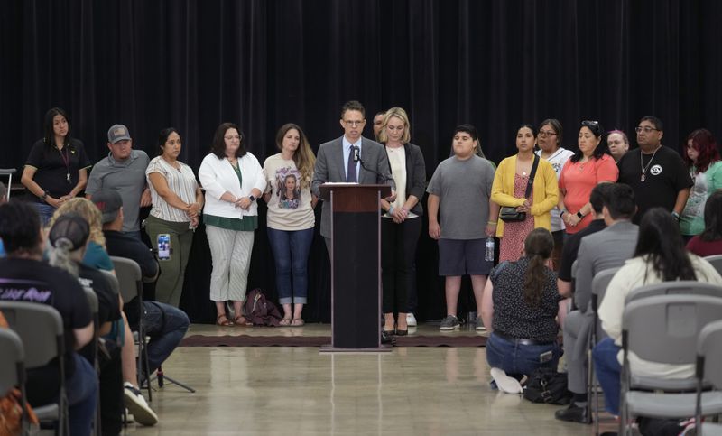 Families of the victims of the Uvalde elementary school shooting stand with attorney Josh Koskoff, center, during a news conference, Wednesday, May 22, 2024, in Uvalde, Texas. The families of 19 of the victims announced a lawsuit against nearly 100 state police officers who were part of the botched law enforcement response. The families say they also agreed a $2 million settlement with the city, under which city leaders promised higher standards and better training for local police. (AP Photo/Eric Gay)