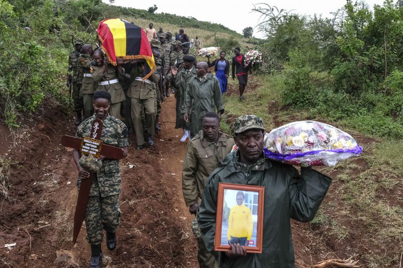 Members of the Uganda People's Defense Force carry the casket of Ugandan Olympic athlete Rebecca Cheptegei ahead of her burial in Kapkoros, Bukwo District, Uganda, on Saturday, Sept. 14. 2024. (AP Photo/Hajarah Nalwadda)