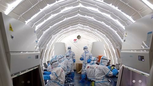 FILE - In this file photo released by China's Xinhua News Agency, staff members work in an inflatable COVID-19 testing lab provided by Chinese biotech company BGI Genomics, a subsidiary of BGI Group, in Beijing, June 23, 2020. (Chen Zhonghao/Xinhua via AP, File)