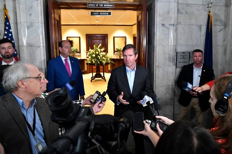 Kentucky Gov. Andy Beshear, center, answers questions after signing an executive order banning the use of “conversion therapy” on minors, Wednesday, Sept. 18, 2024, in Frankfort, Ky. (AP Photo/Timothy D. Easley)