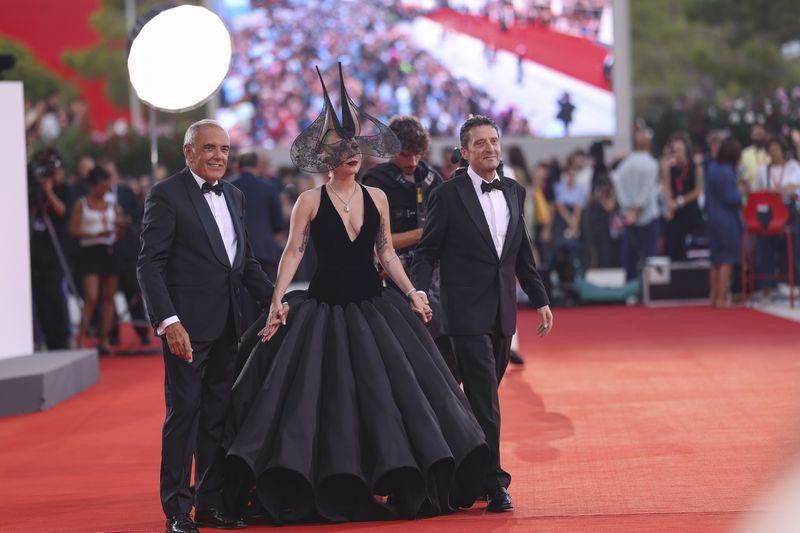 Venice Film Festival Artistic Director Alberto Barbera, from left, Lady Gaga and Pietrangelo Buttafuoco pose for photographers upon arrival for the premiere of the film 'Joker: Folie A Deux' during the 81st edition of the Venice Film Festival in Venice, Italy, on Wednesday, Sept. 4, 2024. (Photo by Vianney Le Caer/Invision/AP)