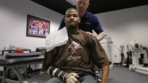 Inky Johnson, a University of Tennessee football player from Crim High School in Atlanta, going through therapy in their Knoxville sports complex May 23, 2007. John Dean, the Director of Rehabilitation for the Tennessee men's athletic department, is assisting him. Johnson suffered a career-ending shoulder injury in a game the year before.  (Louie Favorite / AJC file)