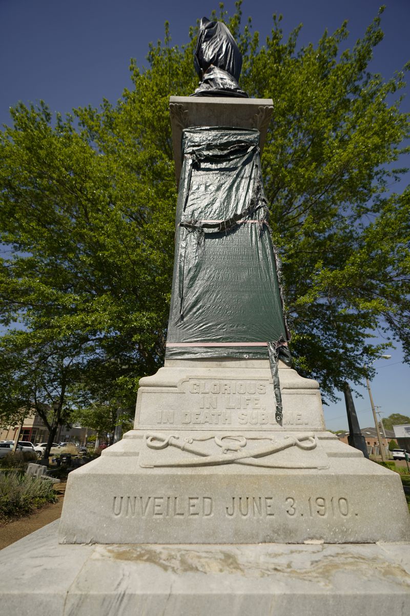 A century-old Confederate memorial statue is outlined underneath the weather-worn tarp covering the monument in Grenada, Miss., April 12, 2023. (AP Photo/Rogelio V. Solis)