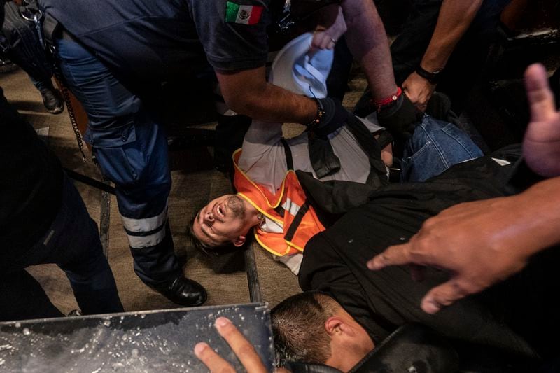 Medics tend to an injured protester after demonstrators broke into the Senate interrupting a debate on the government's proposed judicial reform, which would make judges stand for election, in Mexico City, Tuesday, Sept. 10, 2024. (AP Photo/Felix Marquez)