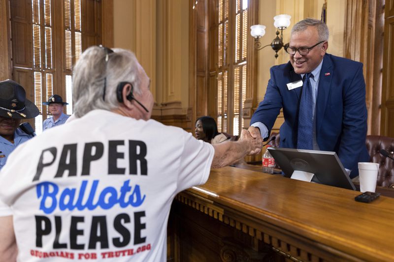 FILE - From left, State Election Board Executive Director Mike Coan greets an election skeptic after a hastily planned State Election Board meeting at the Capitol in Atlanta, July 12, 2024. (Arvin Temkar/Atlanta Journal-Constitution via AP, FILE)