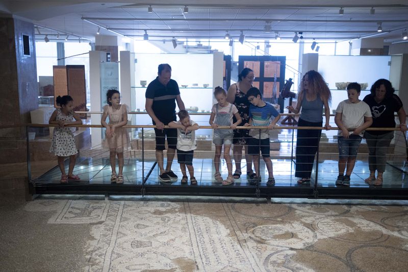 Ariel Heller, 4, center left, and his father Alex, third left, take part in a special tour with their family and friends after the child accidentally broke an ancient jar at the Reuben and Edith Hecht Museum in Haifa, Israel, Friday, Aug. 30, 2024. The boy who accidentally broke a rare 3,500-year-old jar in an Israeli museum has been forgiven and invited back, as curators hope to turn the disaster into a teachable moment. (AP Photo/Maya Alleruzzo)