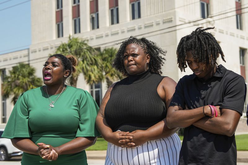 Darryl George,18, stands next to his attorney Allie Booker, and his mother, Darresha George in front of Galveston County Court House on Thursday, May 23, 2024, in Galveston, Texas. A hearing was set to be held Thursday in a federal lawsuit a George filed against his Texas school district over his punishment for refusing to change his hairstyle. (Raquel Natalicchio/Houston Chronicle via AP)