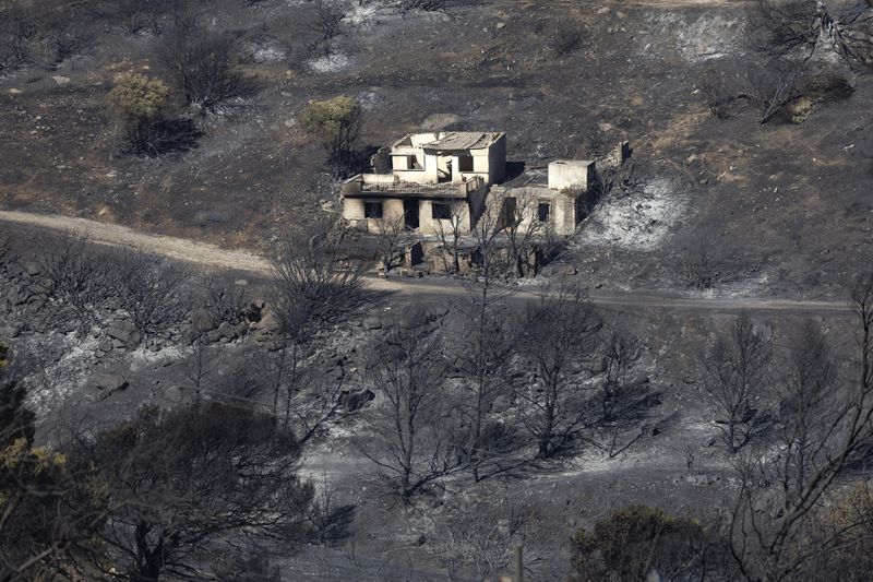 A destroyed home is seen amidst a burnt area after a wildfire at Keratea area, southeast of Athens, Greece, Sunday, June 30, 2024. (AP Photo/Yorgos Karahalis)