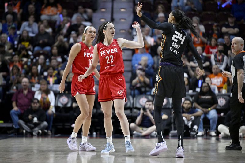 Indiana Fever guard Caitlin Clark (22) and Connecticut Sun forward DeWanna Bonner (24) exchange words during the first half in Game 2 of a first-round WNBA basketball playoff series, Wednesday, Sept. 25, 2024, in Uncasville, Conn. (AP Photo/Jessica Hill)