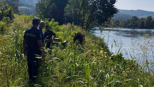 In this photograph made available by the Serbian Ministry of Interior, Serbian Police officers search a bank of the Drina River near the town of Ljubovija, Serbia, Thursday, Aug. 22, 2024. (Serbian Ministry of Interior via AP)