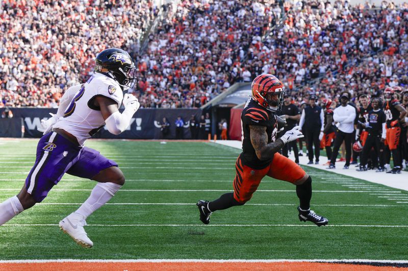 Cincinnati Bengals running back Chase Brown, right, runs in a touchdown after making a catch in front of Baltimore Ravens linebacker Trenton Simpson during the second half of an NFL football game, Sunday, Oct. 6, 2024, in Cincinnati. (AP Photo/Jeff Dean)