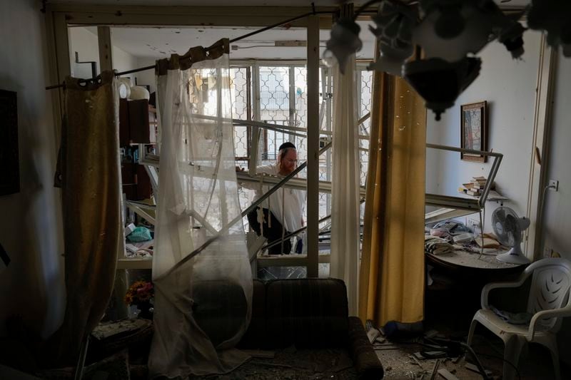 A man examine his damaged apartment that was hit by a rocket fired from Lebanon, in Kiryat Yam, northern Israel, on Tuesday, Oct. 8, 2024. (AP Photo/Ariel Schalit)