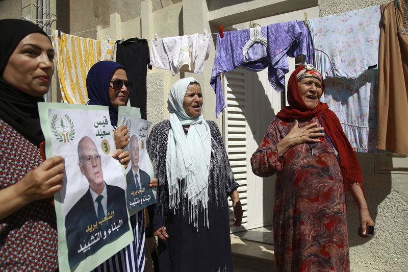 Supporters of Tunisian President and candidate for re-election Kais Saied meet with residents of a neighbourhood during a campaign tour, in Ariana, Tunisia, Thursday, Sept. 26, 2024. (AP Photo/Anis Mili)