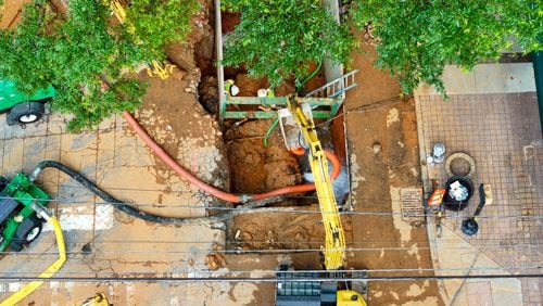 In this iron image, crews are spotted continuing to work on a broken main on West Peachtree Street at 11th Street in Midtown on Monday afternoon, the fourth day of the crisis’s beginning.
(Miguel Martinez / AJC)