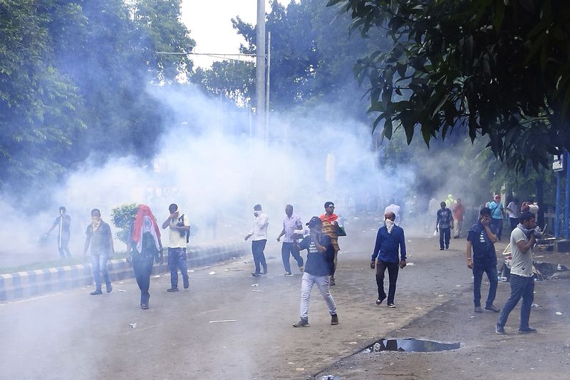 Police fire tear gas shells to disperse people protesting against the rape and murder of a resident doctor at a government hospital earlier this month, in Kolkata, India, Tuesday, Aug. 27, 2024. (AP Photo/Bikas Das)