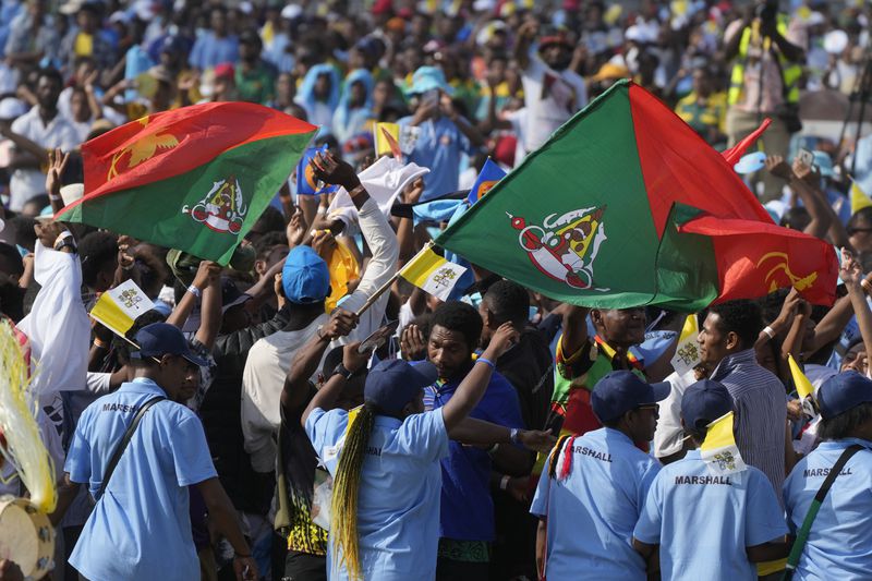 Attendees wave flags of Papua New Guinea East Sepik province during a meeting between Pope Francis and young people at the Sir John Guise stadium in Port Moresby, Monday, Sept. 9, 2024. (AP Photo/Gregorio Borgia)