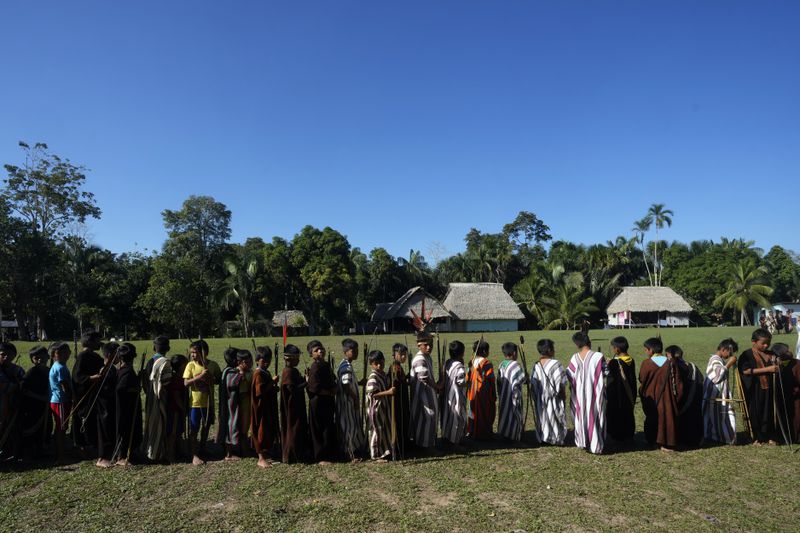 Ashaninka Indigenous children prepare for a bow and arrow competition during the annual celebration recognizing the Ashaninka territory in the Apiwtxa village, Acre state, Brazil, Sunday, June 23, 2024. (AP Photo/Jorge Saenz)