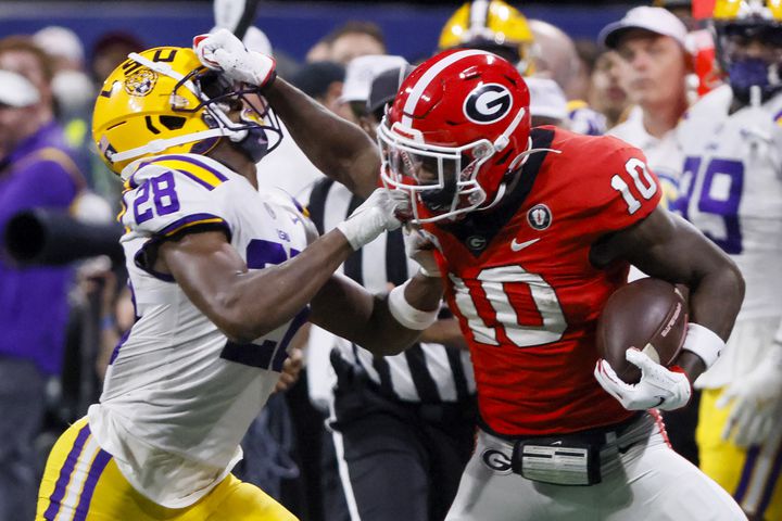 Georgia Bulldogs wide receiver Kearis Jackson (10) stiff arms LSU Tigers safety Major Burns (28) who grabs his face mask during the second half of the SEC Championship Game at Mercedes-Benz Stadium in Atlanta on Saturday, Dec. 3, 2022. (Bob Andres / Bob Andres for the Atlanta Constitution)