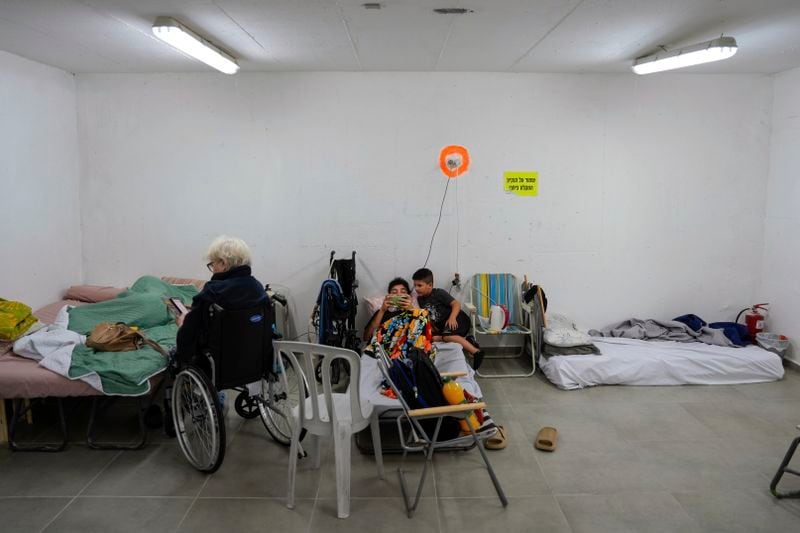 Israelis rest in a residential building bomb shelter to stay safe from rockets fired from Lebanon, in Kiryat Haim, northern Israel, on Tuesday, Sept. 24, 2024. (AP Photo/Baz Ratner)