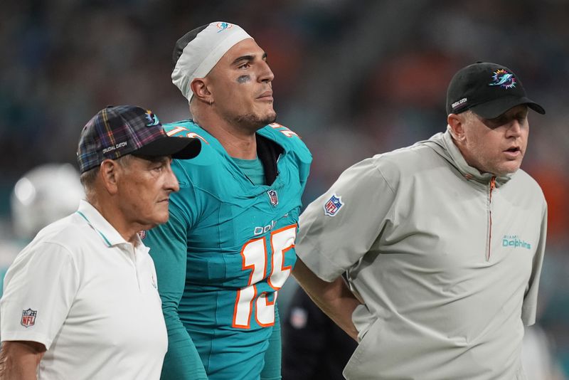 Miami Dolphins linebacker Jaelan Phillips (15) is assisted off the field during the second half of an NFL football game against the Tennessee Titans, Monday, Sept. 30, 2024, in Miami Gardens, Fla. (AP Photo/Rebecca Blackwell)