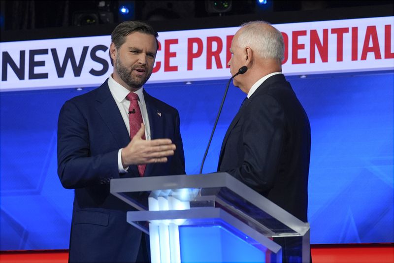 Republican vice presidential nominee Sen. JD Vance, R-Ohio, talks with Democratic vice presidential candidate Minnesota Gov. Tim Walz after the vice presidential debate hosted by CBS News Tuesday, Oct. 1, 2024, in New York. (AP Photo/Matt Rourke)