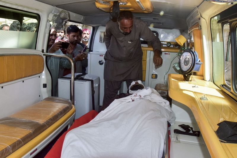 Relatives look at the body of passenger, killed by gunmen at a highway in Musakhail, inside an ambulance after collecting it from a hospital, in Quetta, Pakistan, Monday, Aug. 26, 2024. (AP Photo/Arshad Butt)