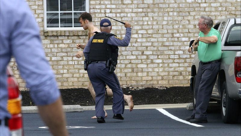 A naked Matthew Thomas Bernard, 18, tries to flee Tuesday, Aug. 27, 2019, near his Keeling, Va., home. Bernard is charged with murder in the deaths of his mother, Joan Bernard, 62, his sister, Emily Bivens, 24, and Bivens' 14-month-old son, Cullen.